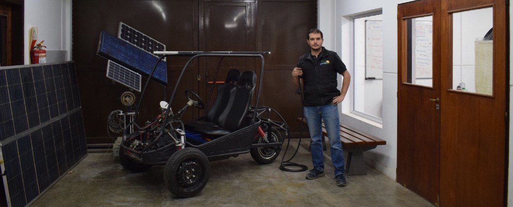 El ingeniero Nicolás Brizzio posa al lado del auto biplaza en el Laboratorio de Electromivilidad.
