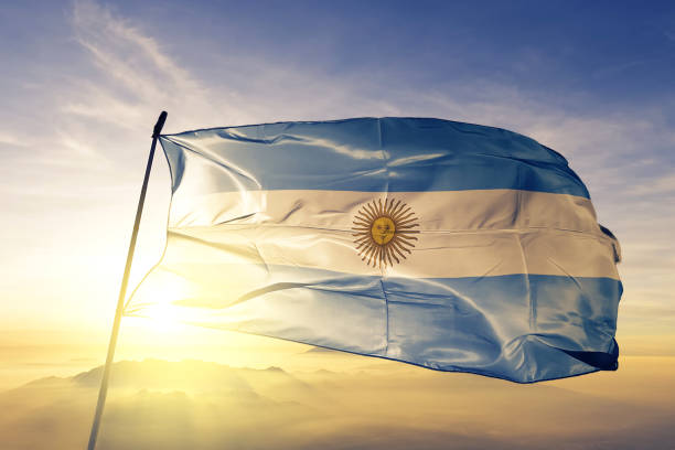 Argentina Argentine Argentinian flag on flagpole textile cloth fabric waving on the top sunrise mist fog